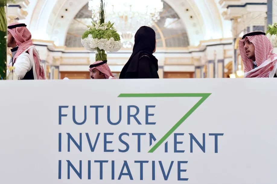 Attendees walk past a Future Investment Initiative sign in Riyadh